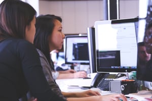 Canva - Two Women Sitting in Front of Computer Monitor