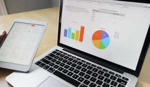 a laptop showing the data analytics of a non-profit organization in the form of a chart and a pie graph