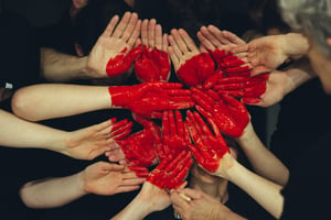 hands painted red to make the shape of a heart